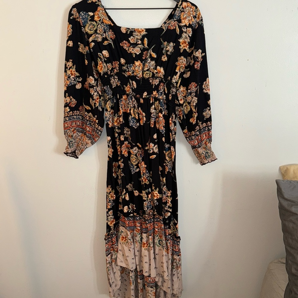 Black dress with multicolored flowers and a flowy bottom with puffy sleeves.